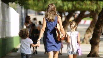 Una madre paseando con sus dos hijos