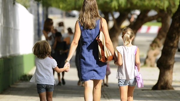 Una madre paseando con sus dos hijos