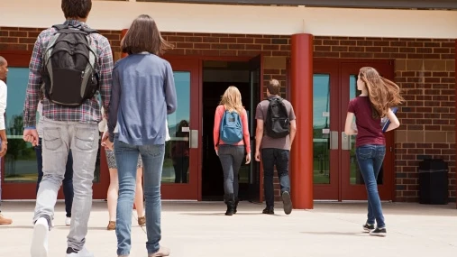 Una pareja de adolescentes entrando al instituto