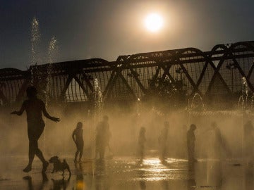 Varias personas se refrescan en las fuentes de Madrid Río