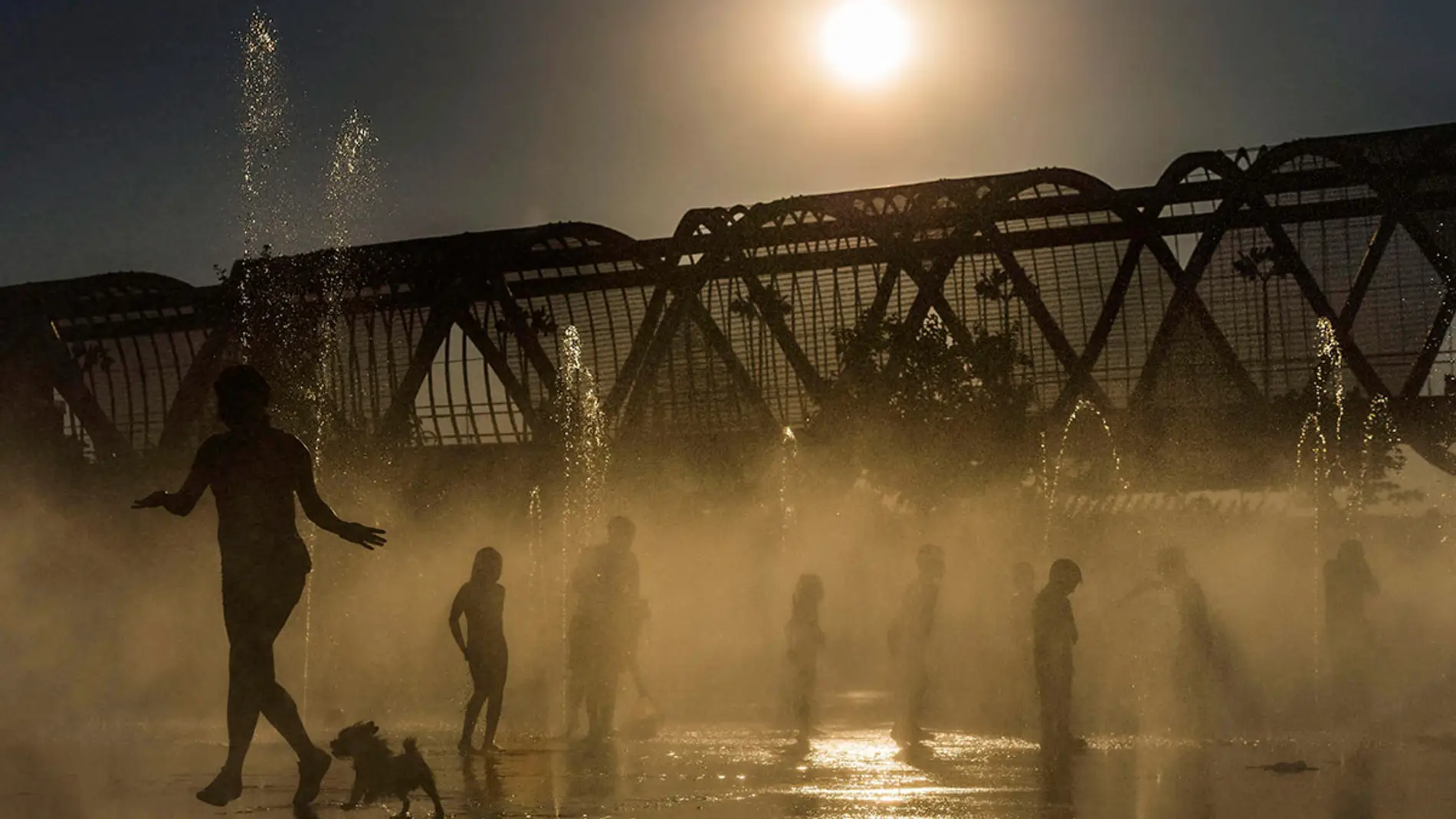 Varias personas se refrescan en las fuentes de Madrid Río