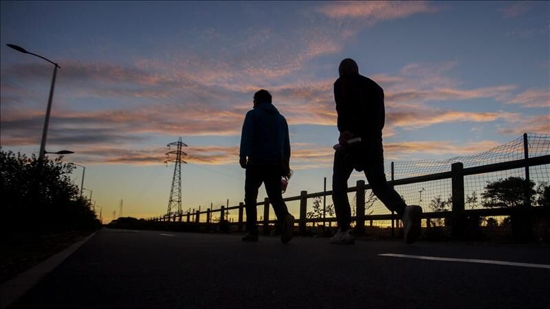 Fotografía facilitada de un par de inmigrantes que se dirigen al túnel del Canal de la Mancha