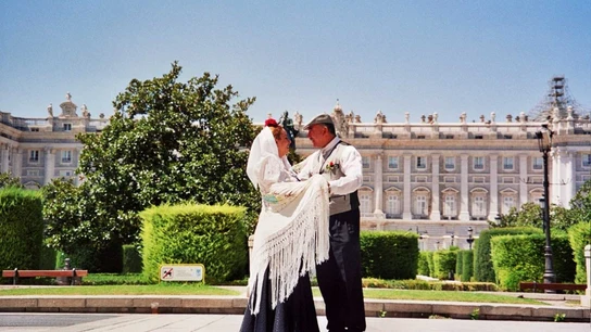 Dos personas bailan el tradicional chotis madrileño frente al Palacio Real de Madrid. El chotis madrileño