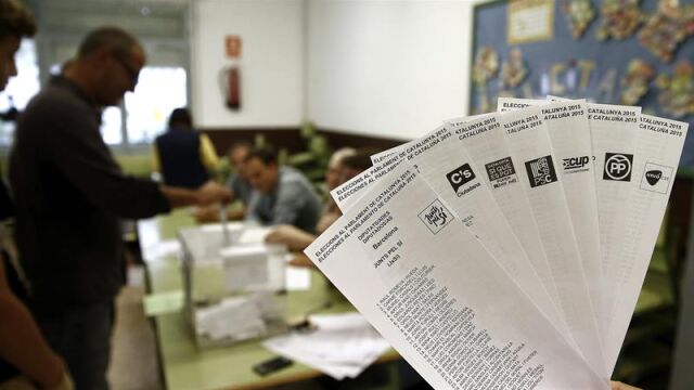 Una persona muestra las papeletas de los diferentes partidos que concurren a las elecciones al Parlamento Catalán. 