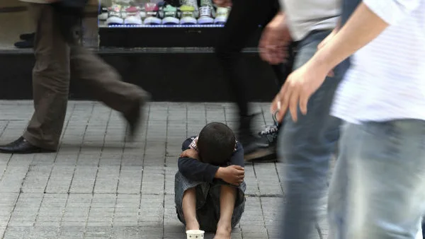 Un niño pide limosna en una calle