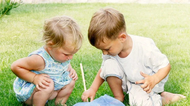 Imagen de dos niños jugando en el césped Imagen de dos niños jugando en el césped