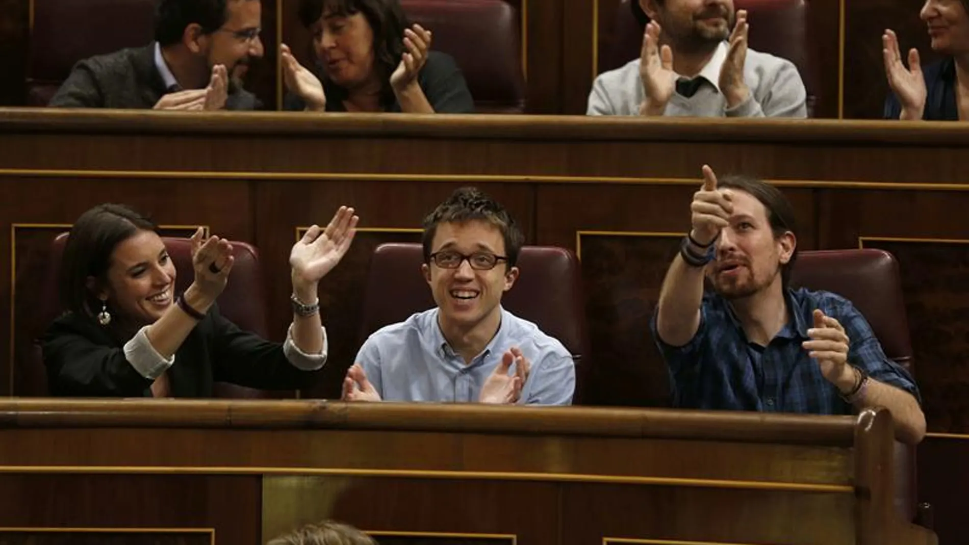 Irene Montero, Iñigo Errejón, y Pablo Iglesias aplauden desde su escaño