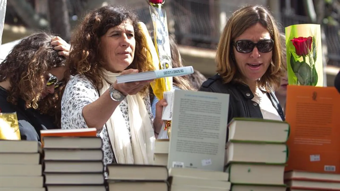 Mujeres con un libro y una rosa para celebrar Sant Jordi Mujeres con un libro y una rosa para celebrar Sant Jordi
