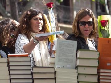 Mujeres con un libro y una rosa para celebrar Sant Jordi Mujeres con un libro y una rosa para celebrar Sant Jordi