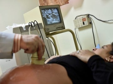 Una mujer embarazada realizándose una ecografía Una mujer embarazada realizándose una ecografía