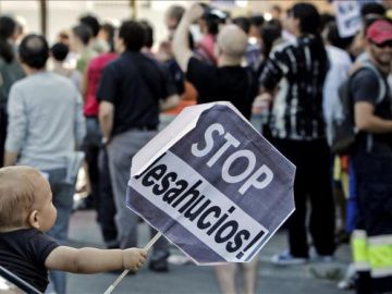 Un niño sostiene un cartel de Stop desahucios (Archivo) Un niño sostiene un cartel de Stop desahucios (Archivo)