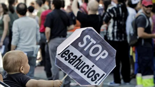 Un niño sostiene un cartel de Stop desahucios, en una imagen de archivo.