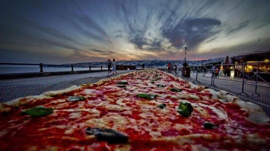 Una pizza napolitana de dos kil&oacute;metros de largo, elaborada para batir el r&eacute;cord del mundo, y colocada a lo largo del paseo mar&iacute;timo en N&aacute;poles (Italia)