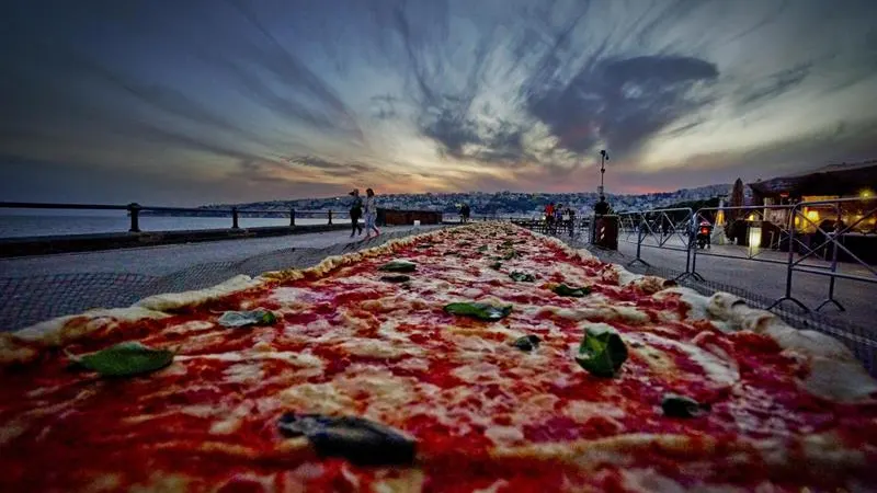 Una pizza napolitana de dos kilómetros de largo, elaborada para batir el récord del mundo, y colocada a lo largo del paseo marítimo en Nápoles (Italia)