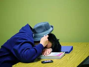 Una persona domida sobre una mesa Una persona domida sobre una mesa