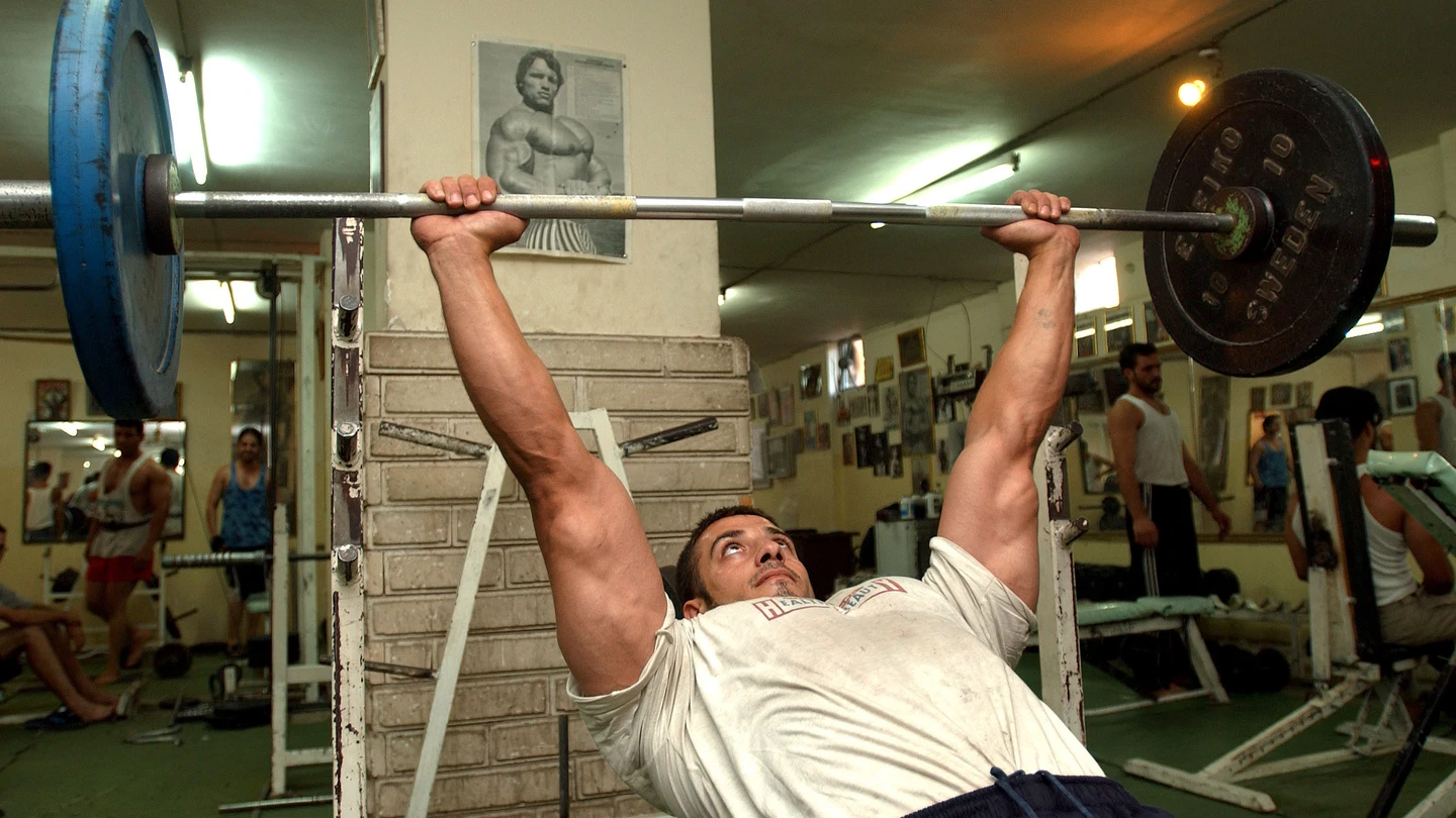 Un hombre trabaja con pesas en el gimnasio Un hombre trabaja con pesas en el gimnasio