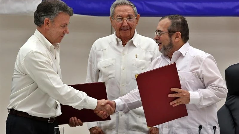 El líder de las FARC en Cuba, Rodrigo Londoño alias "Timochenko" y el presidente de Colombia, Juan Manuel Santos, junto al presidente de Cuba, Raúl Castro