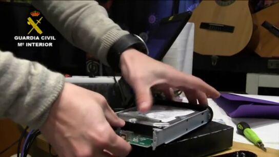 Un guardia civil manipulando una memoria inform&aacute;tica (Archivo)