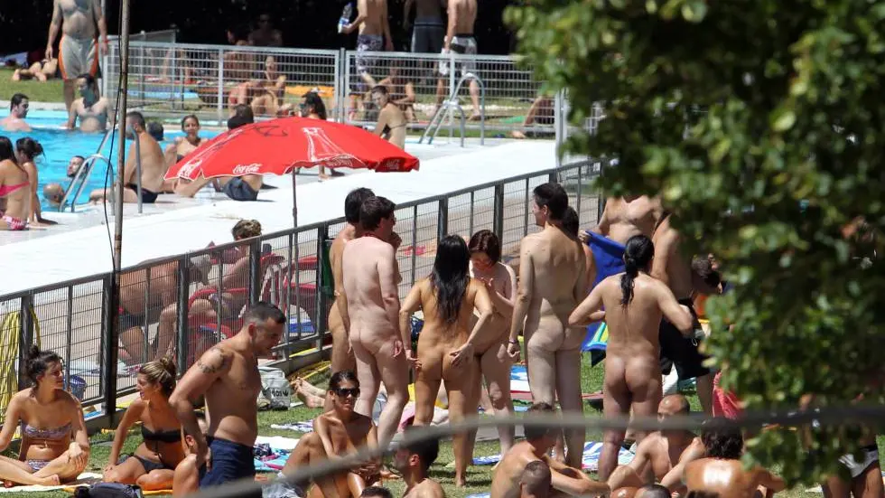 Naturistas bañándose en una piscina municipal