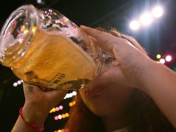 Una mujer bebe una cerveza