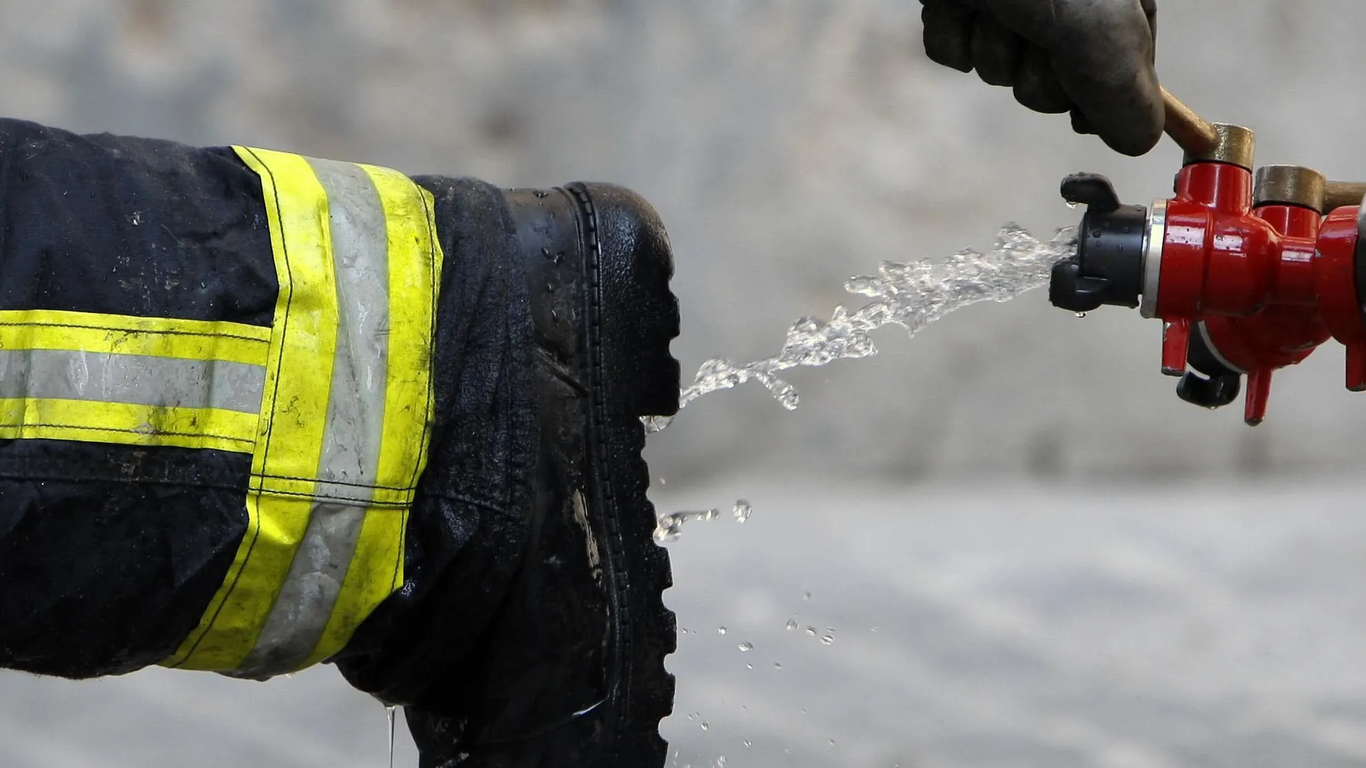 Un bombero limpia sus botas tras declarar extinguido un incendio Un bombero limpia sus botas tras declarar extinguido un incendio