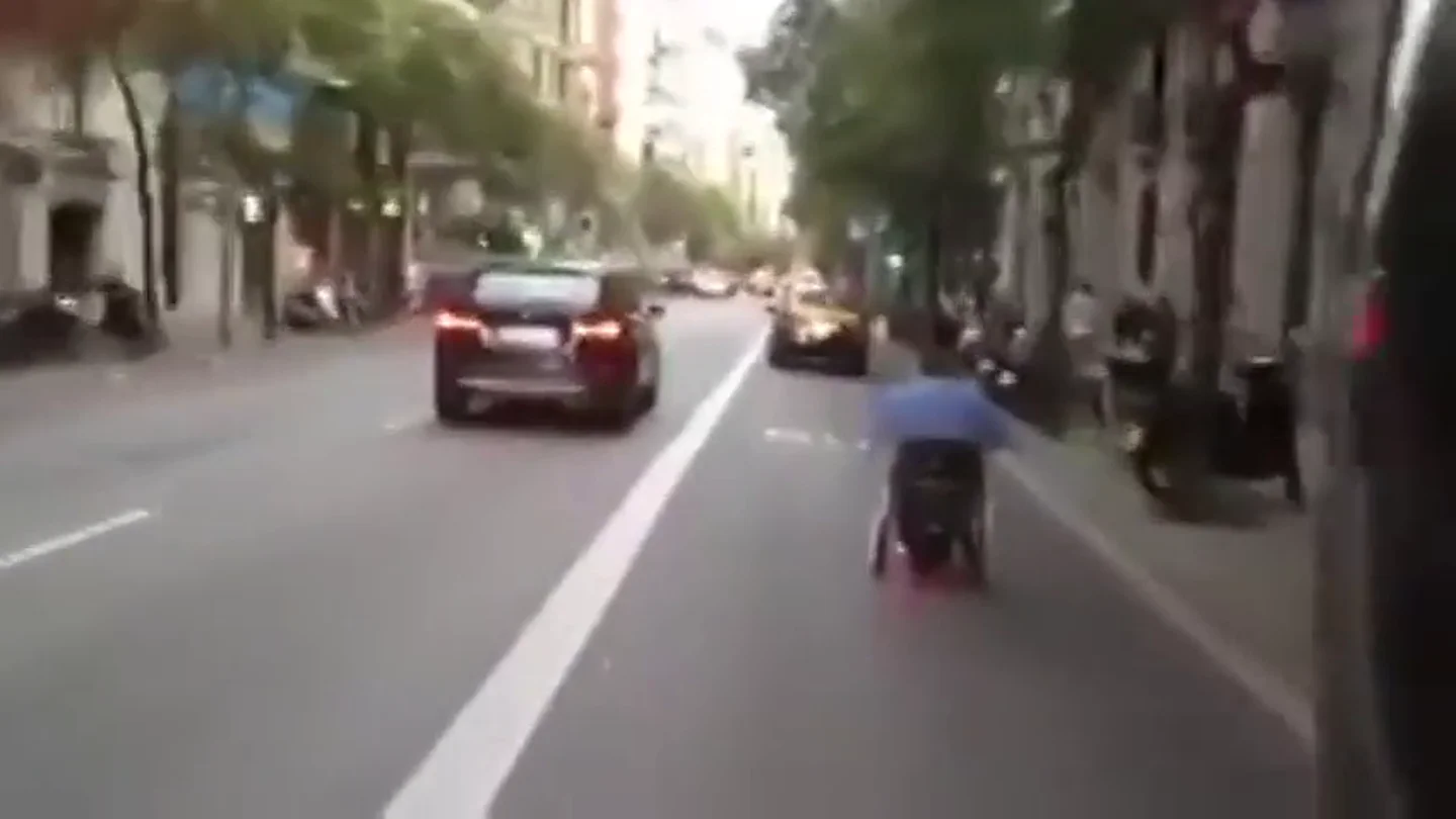 Frame 10.353453 de: Un hombre en silla de ruedas se desplaza a toda velocidad por las calles de Barcelona Frame 10.353453 de: Un hombre en silla de ruedas se desplaza a toda velocidad por las calles de Barcelona