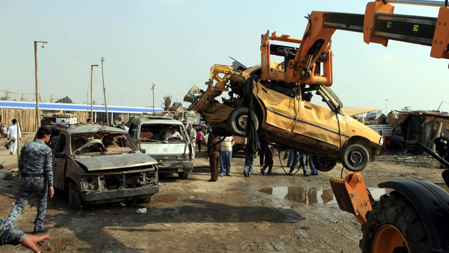 Un polic&iacute;a iraqu&iacute; inspecciona el lugar de un atentado con coche bomba registrado en el barrio de Al Kazemiya, de mayor&iacute;a chi&iacute; y ubicado en el norte de Bagdad (Irak), perpetrado en 2013