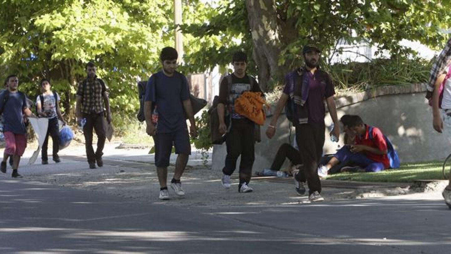 Varios migrantes, de camino a Hungr&iacute;a, marchan por una carretera pr&oacute;xima a Belgrado (Serbia)