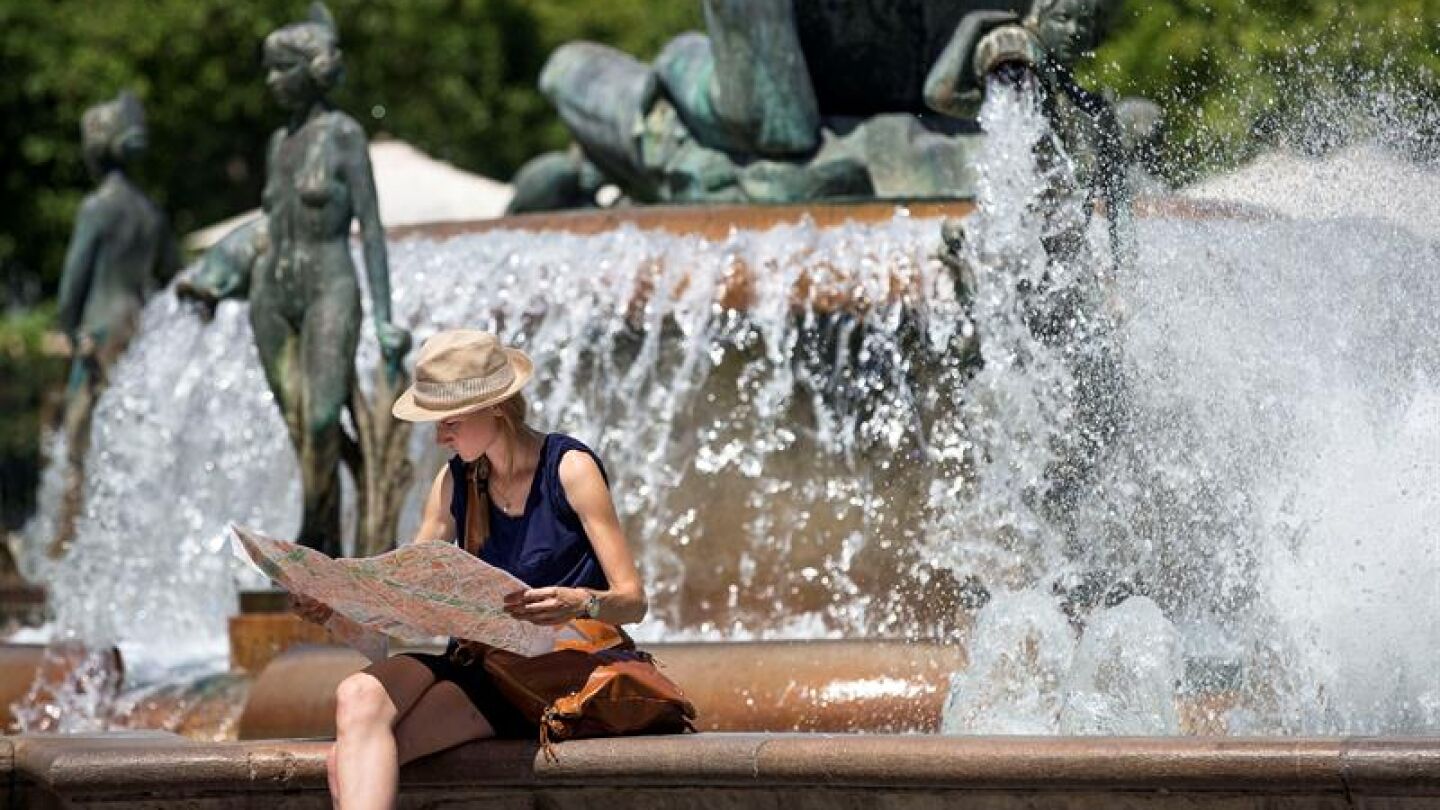 Una turista junto a una fuente