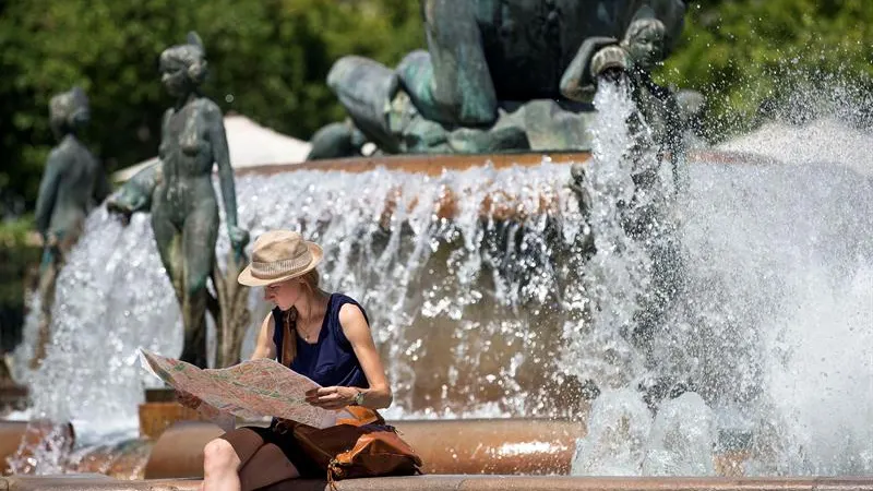 Una turista junto a una fuente