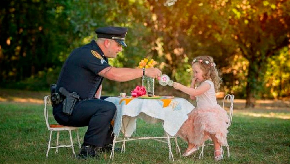 La pequeña de dos años toma el té con el Policía que le salvó la vida.