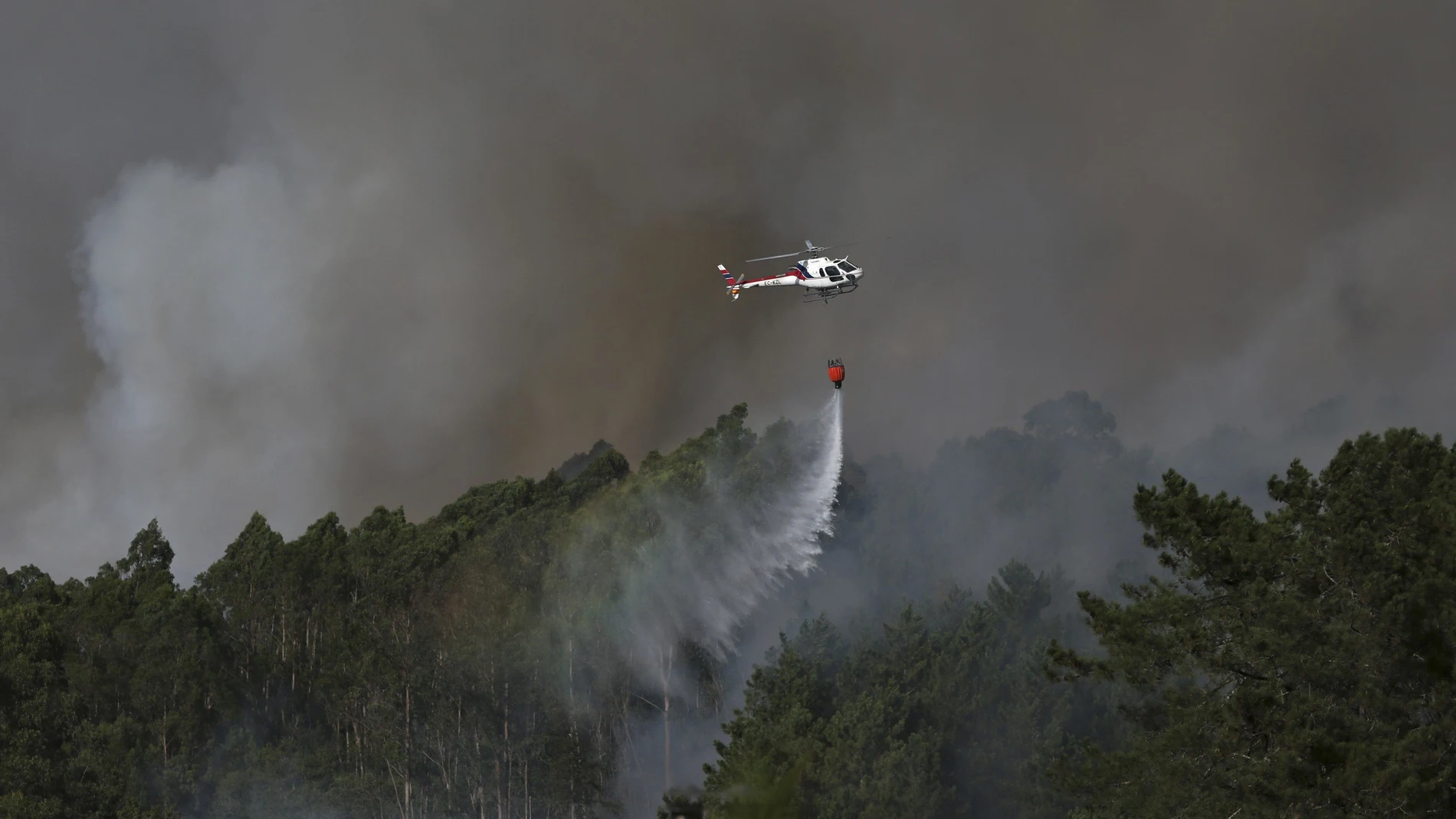  Un helicóptero trabaja en las labores de extinción del incendio originado esta tarde en la parroquia de Tenorio, en Cotobade (Pontevedra)
