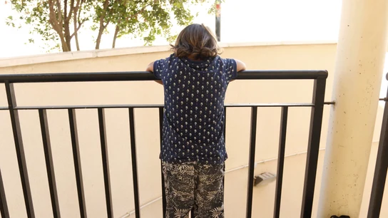 Un niño mira por un balcón Un niño mira por un balcón