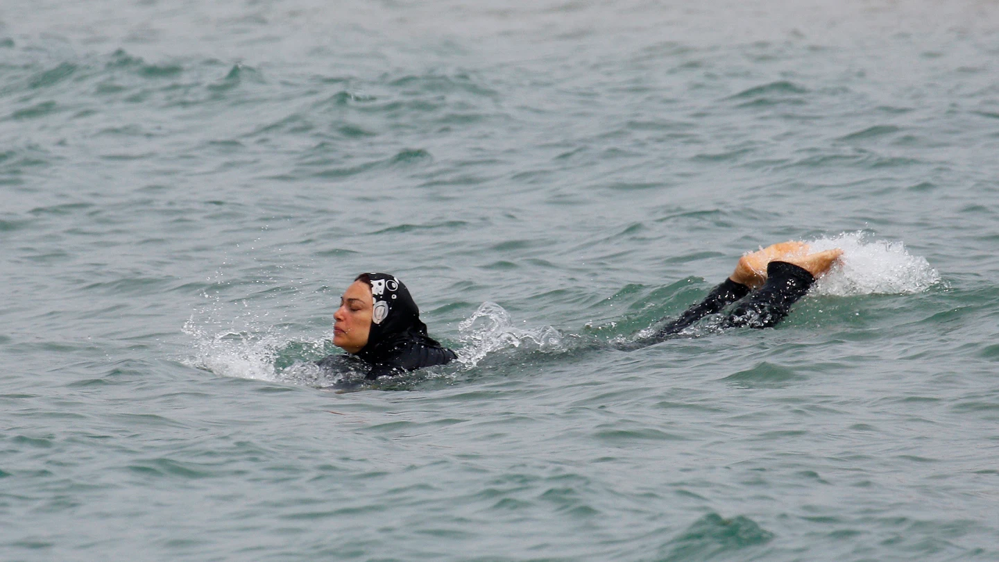 Una mujer con 'burkini' bañándose Una mujer con 'burkini' bañándose
