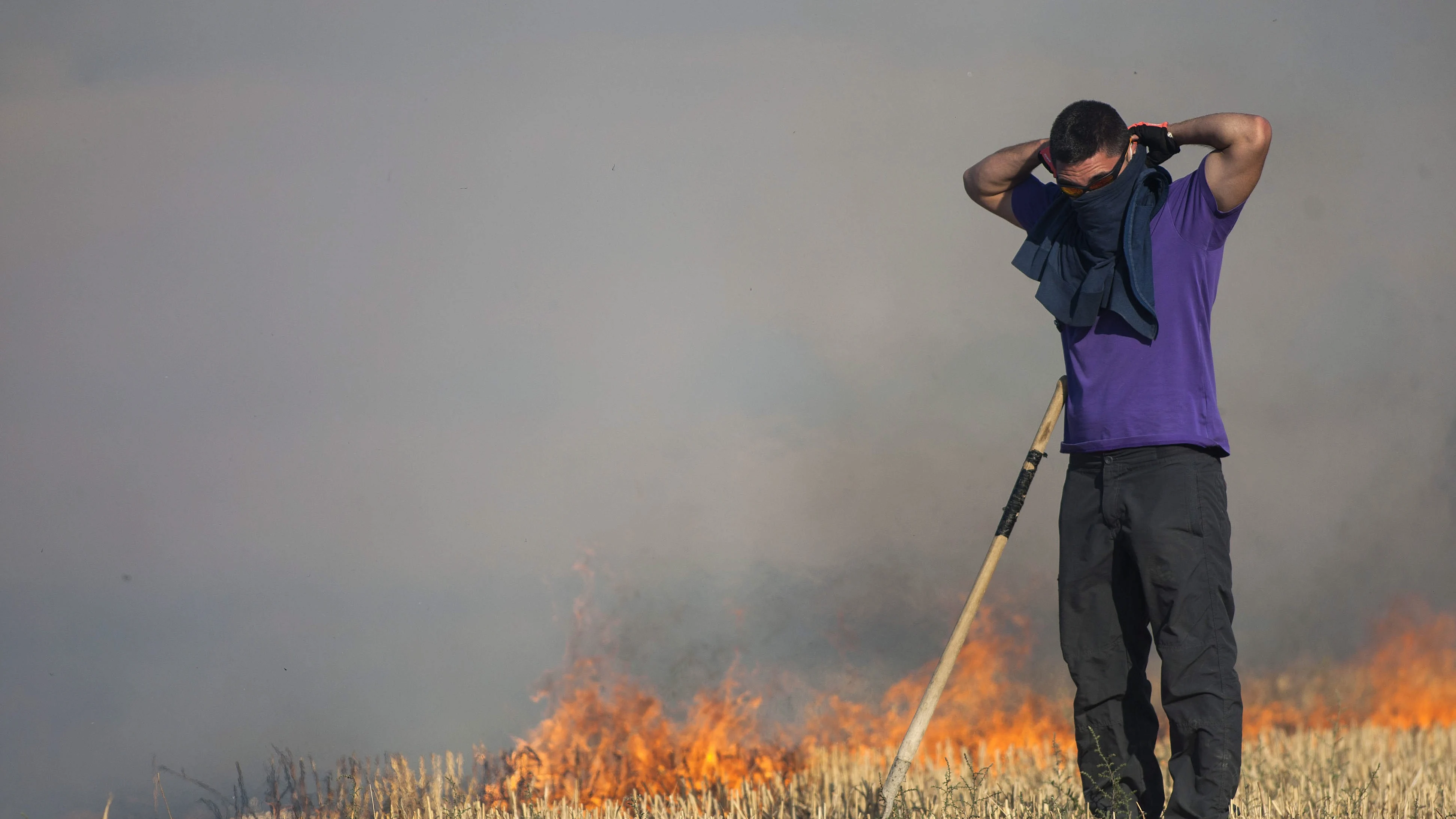 Un miembro de una caudrilla terrestre se prepara para actuar en el incendio