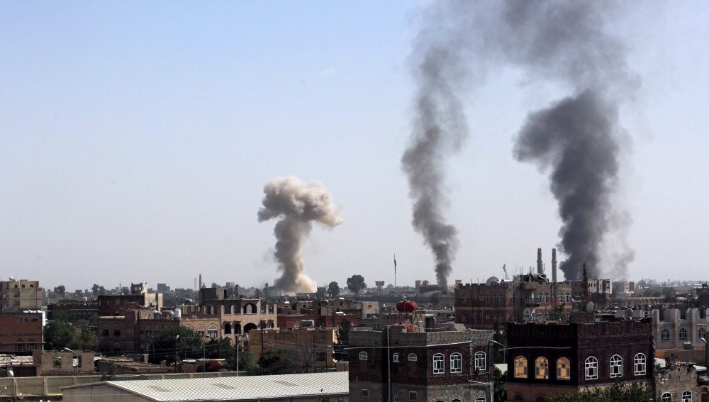 El humo se eleva por encima de la ciudad después de que un ataque aéreo saudí dañase una base militar del grupo rebelde Houthi, en Saná