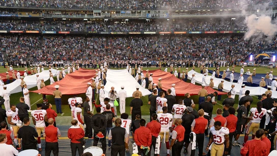 Colin Kaepernick, en la parte inferior de la fotografía (lleva el dorsal 7), de rodillas mientras suena el himno de Estados Unidos Colin Kaepernick, en la parte inferior de la fotografía (lleva el dorsal 7), de rodillas mientras suena el himno de Estados Unidos