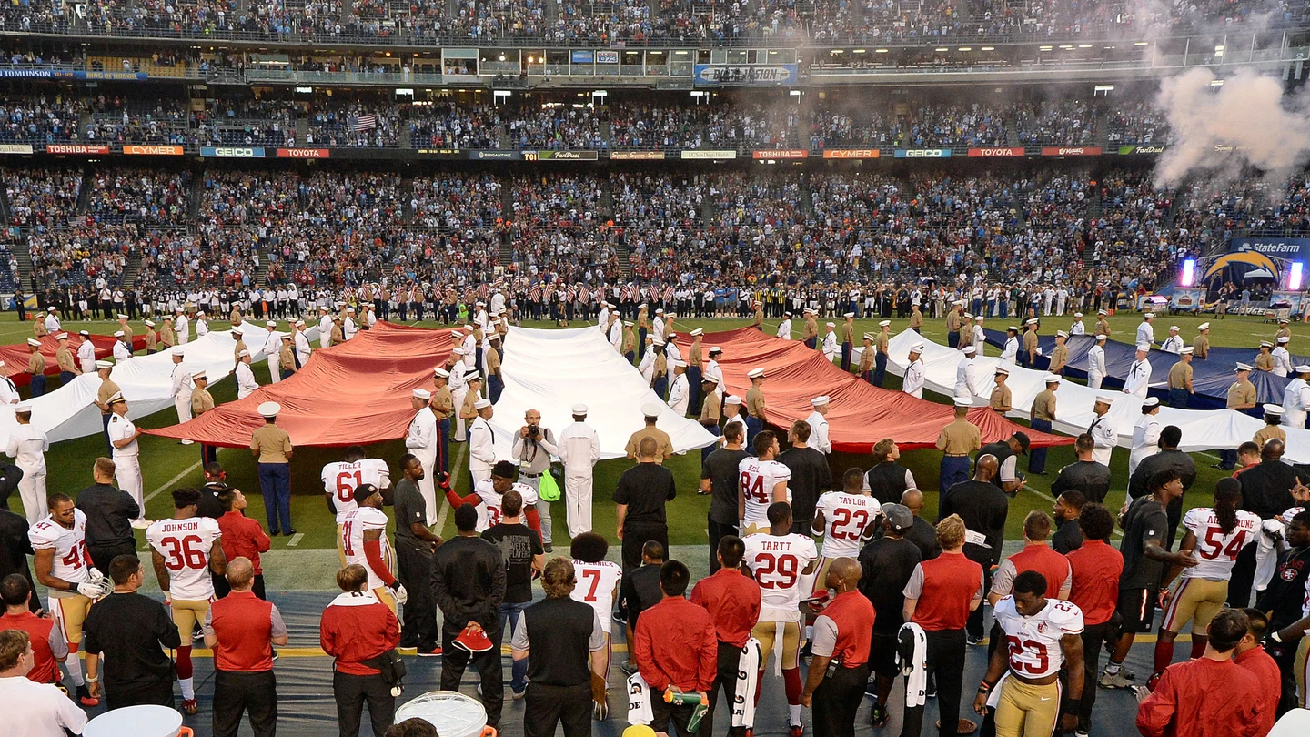 Colin Kaepernick, en la parte inferior de la fotografía (lleva el dorsal 7), de rodillas mientras suena el himno de Estados Unidos Colin Kaepernick, en la parte inferior de la fotografía (lleva el dorsal 7), de rodillas mientras suena el himno de Estados Unidos