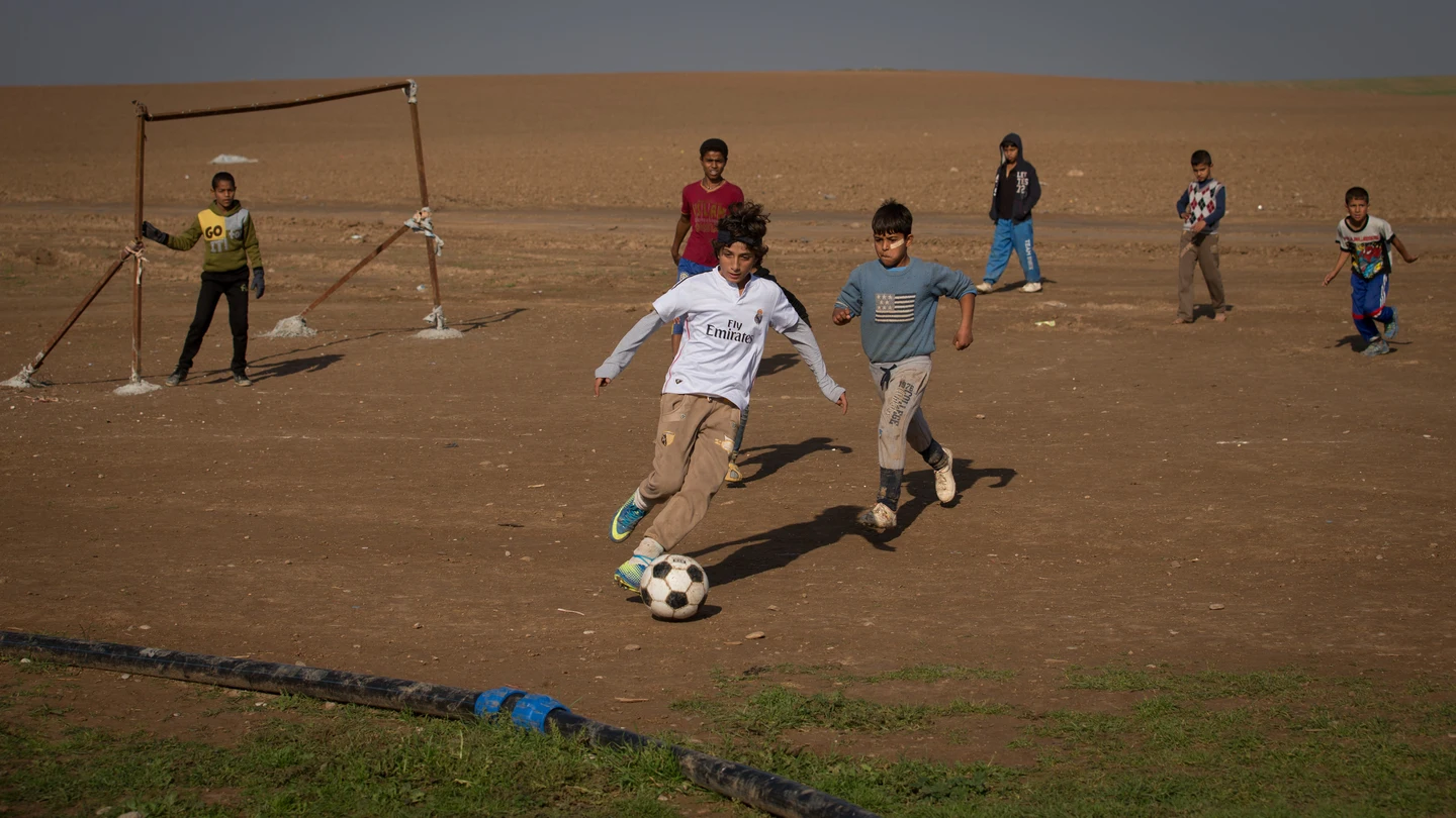 Niños jugando a fútbol en un campo de refugiados del norte de Irak Niños jugando a fútbol en un campo de refugiados del norte de Irak