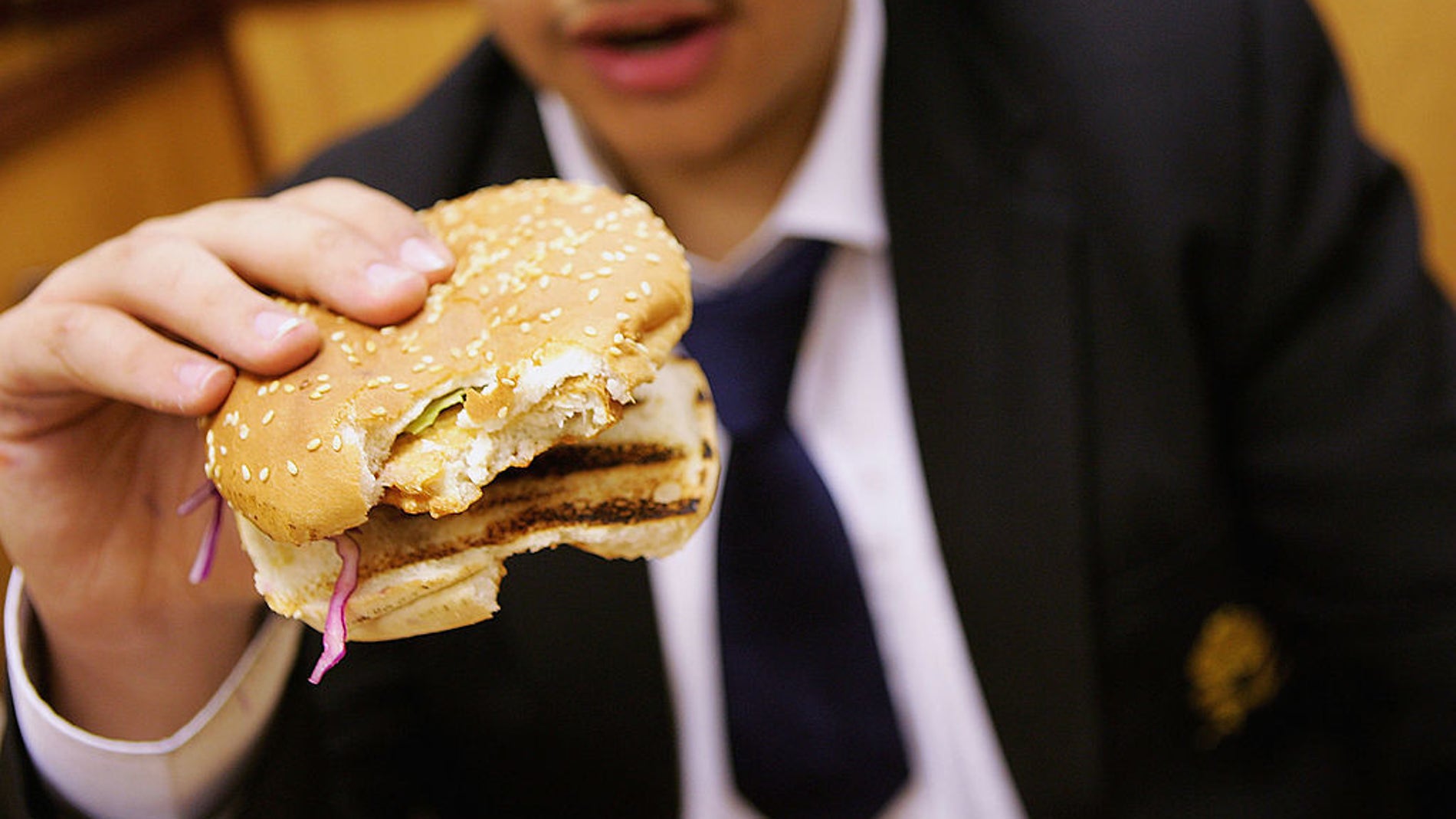 Un colegial come una hamburguesa para almorzar