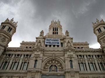 Detalle de una pancarta con la leyenda "Refugees Welcome" -"Refugiados, bienvenidos", colocada en la fachada del Palacio de Cibeles Detalle de una pancarta con la leyenda "Refugees Welcome" -"Refugiados, bienvenidos", colocada en la fachada del Palacio de Cibeles