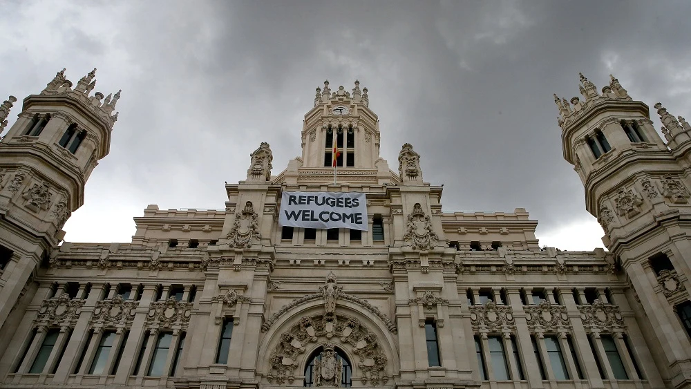 Detalle de una pancarta con la leyenda "Refugees Welcome" -"Refugiados, bienvenidos", colocada en la fachada del Palacio de Cibeles