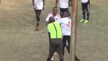 Un árbitro y un jugador pegándose en Zimbabue.
