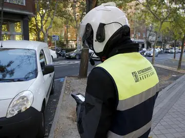 Un agente de movilidad poniendo una multa Un agente de movilidad poniendo una multa