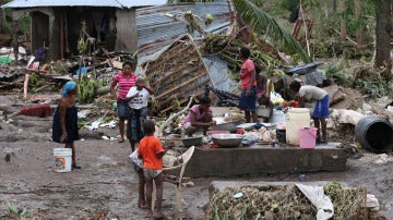 Varias personas intentan recuperar objetos tras el paso del huracán Matthew en Haití