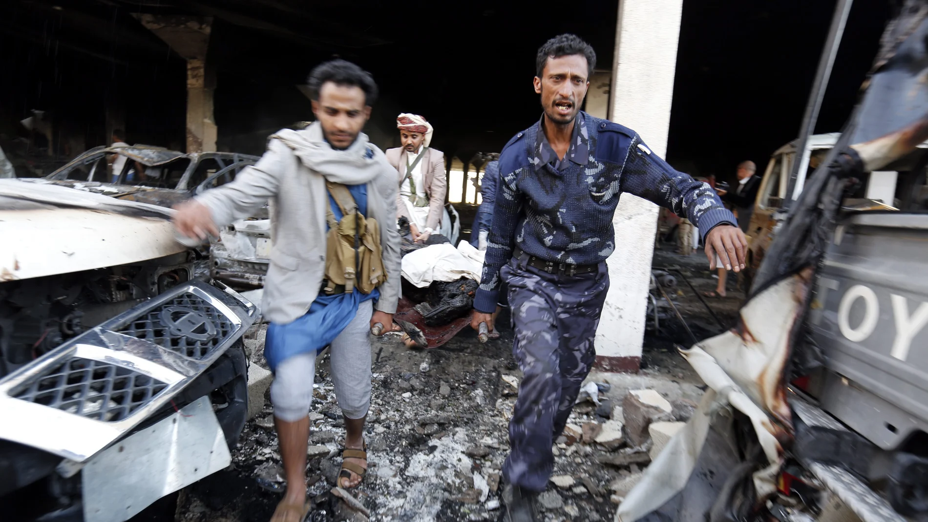 Un grupo de yemeníes transportan el cuerpo de una víctima tras los bombardeos aéreos de la coalición árabe sobre Sanáa, Yemen