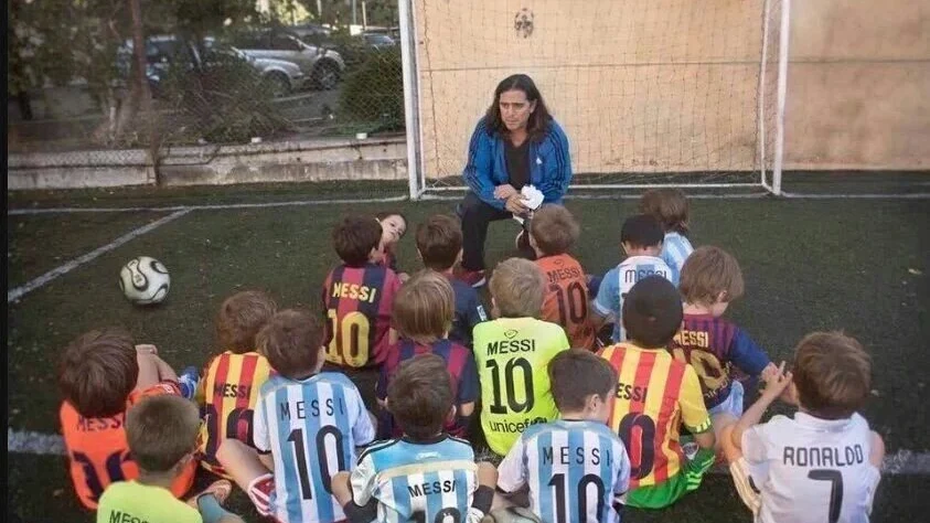 Fernando Signoriri rodeado de un grupo de ni&ntilde;os que apoyan a Messi, menos uno