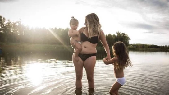 Una madre juega con sus hijos en un lago durante la sesión fotográfica Una madre juega con sus hijos en un lago durante la sesión fotográfica