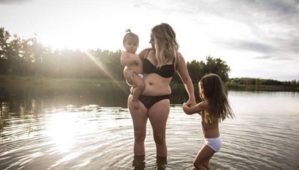 Una madre juega con sus hijos en un lago durante la sesión fotográfica