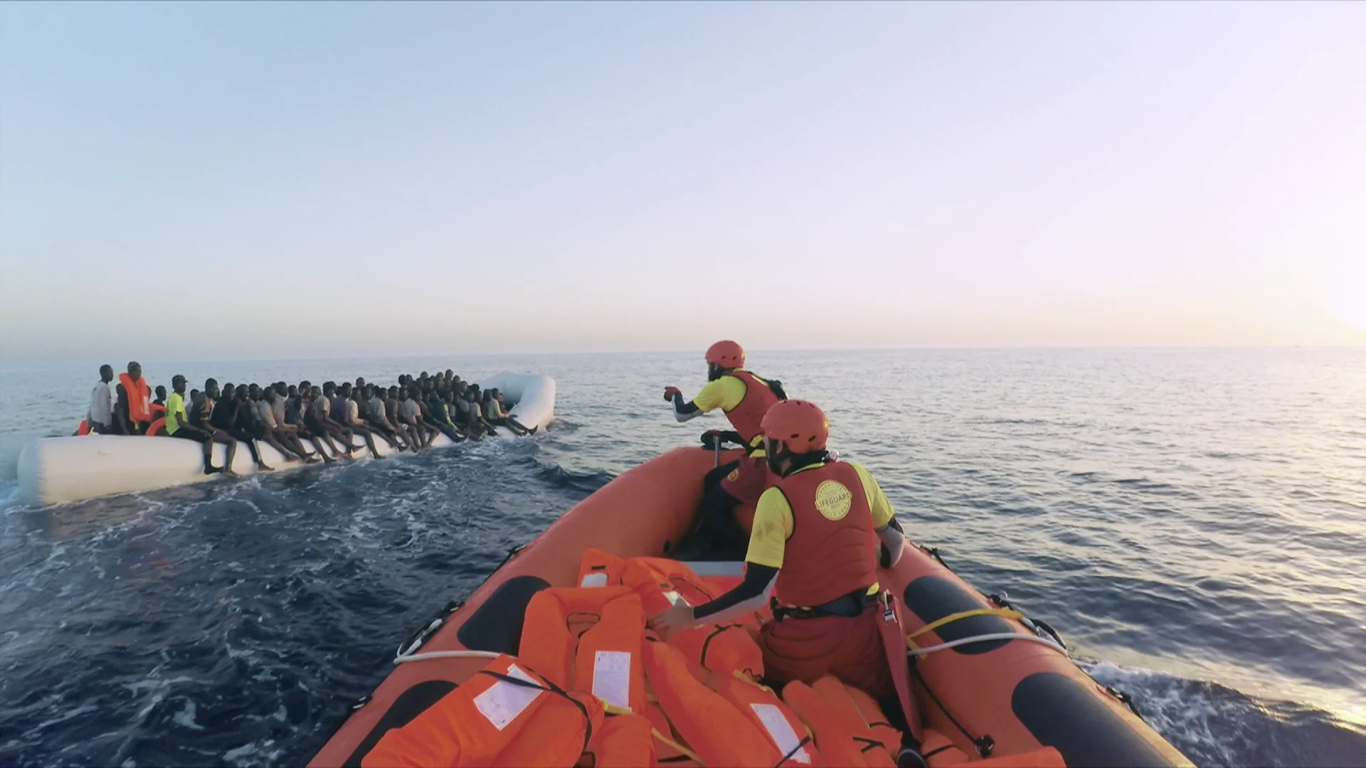 Miembros de ProActiva intentan ayudar a una lancha llena de refugiados